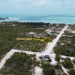 Aerial view showing highlighted lot along main road with ocean in the background near Secret Beach Ambergris Caye Belize