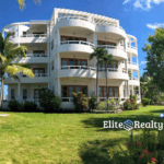 Condo building at Brahma Blue Resort with landscaped grounds and open green space in San Pedro Belize