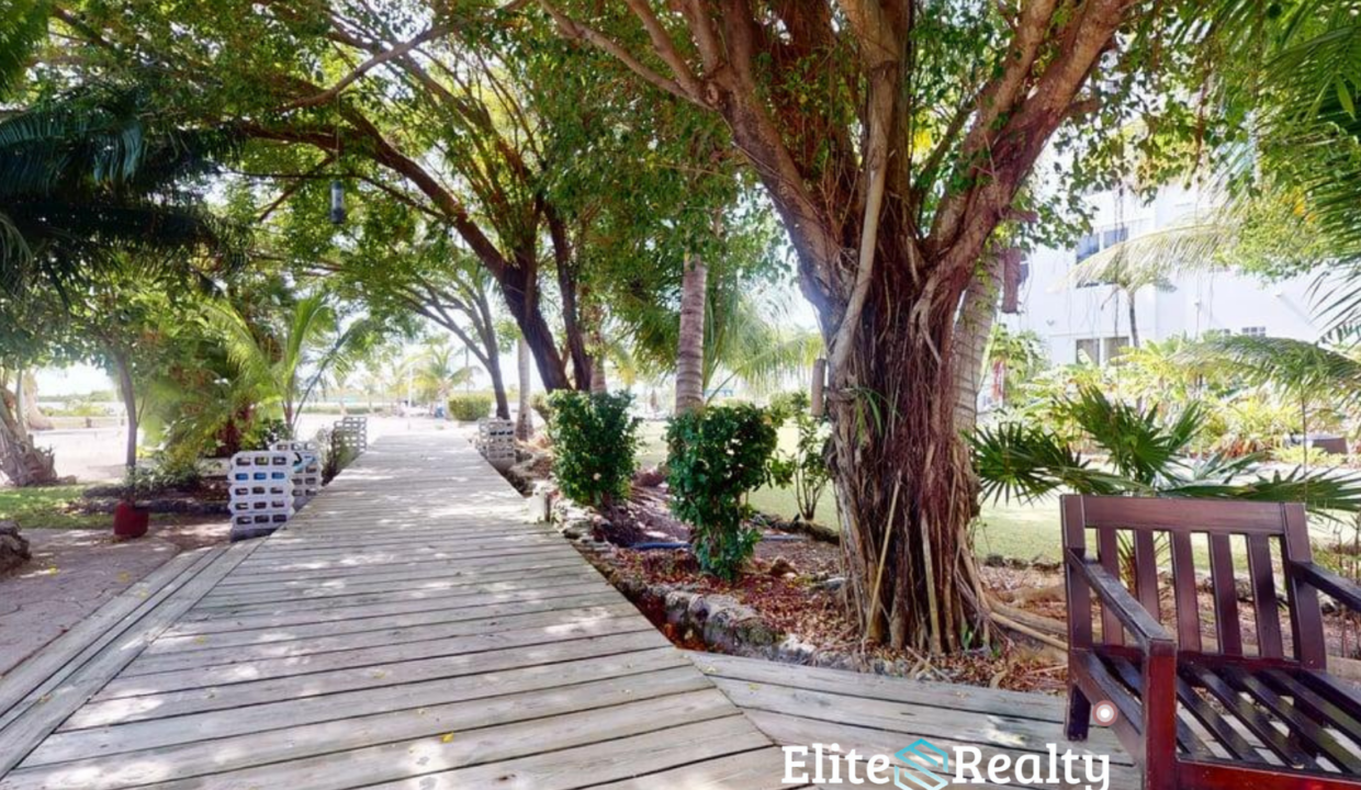 Shaded Tropical Walkway With Seating Area At Brahma Blue Resort San Pedro Belize