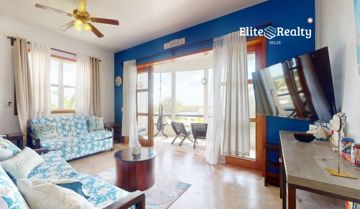 Waterfront Living Room With Seating Tv And Sliding Doors To Balcony At Brahma Blue Resort San Pedro Belize