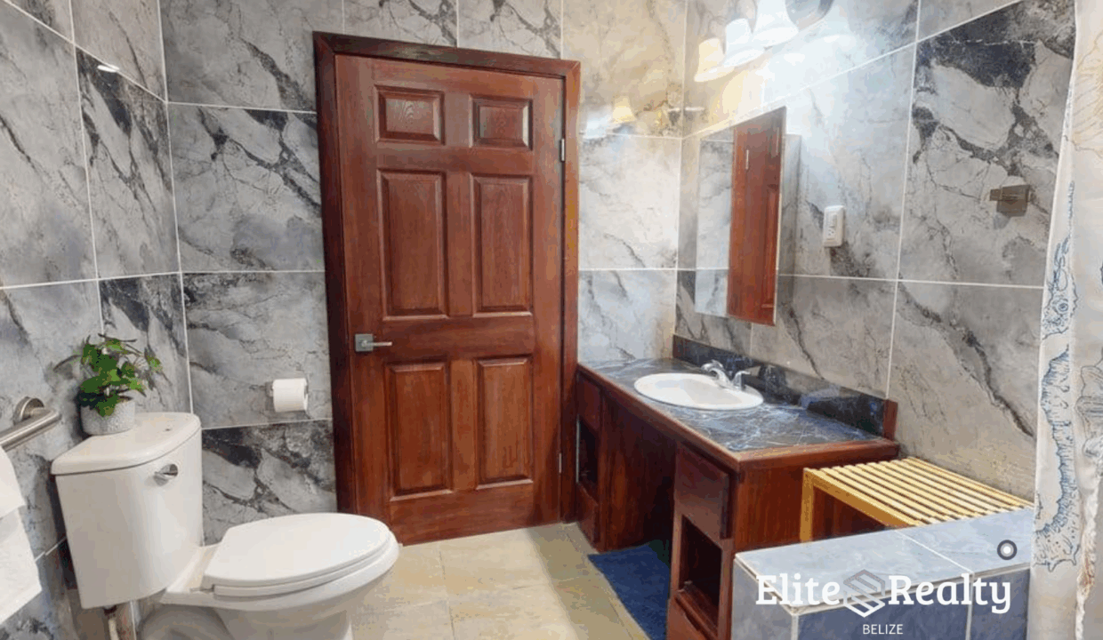 Full Bathroom With Tiled Walls Vanity Sink Toilet And Walk In Shower Blue Water Beach Resort Belize