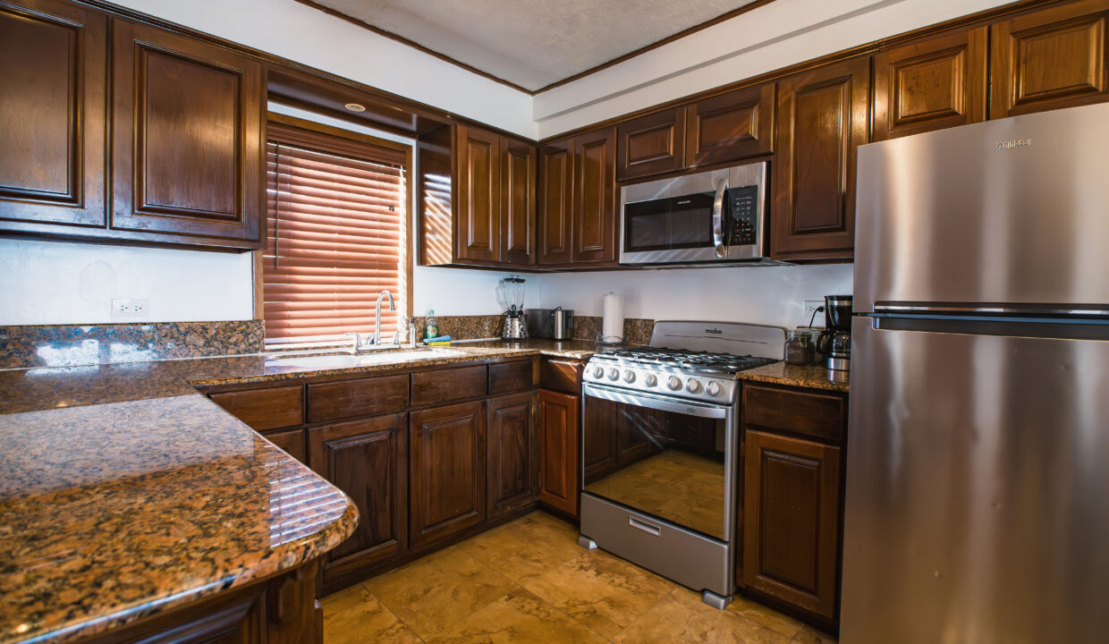 Modern Kitchen With Stainless Steel Appliances And Wooden Cabinets At Hopkins Bay Resort Belize Luxury Caribbean Villa Interior