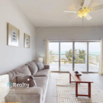 Ocean view living room with balcony at Blue Water Beach Resort beachfront condo for sale in San Pedro Ambergris Caye Belize