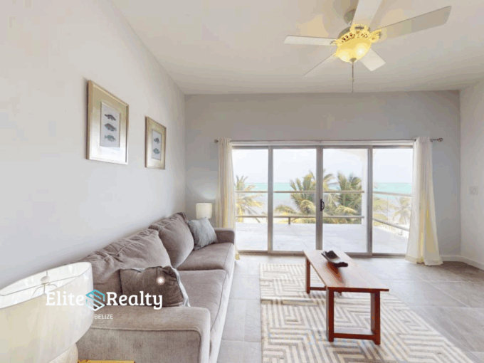 Ocean view living room with balcony at Blue Water Beach Resort beachfront condo for sale in San Pedro Ambergris Caye Belize