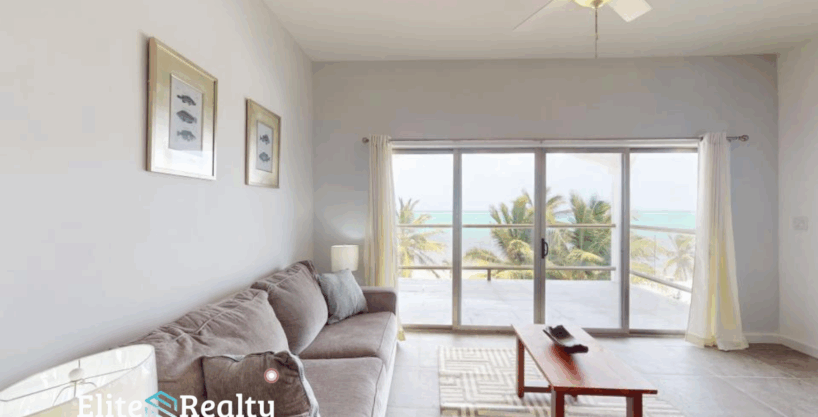 Ocean view living room with balcony at Blue Water Beach Resort beachfront condo for sale in San Pedro Ambergris Caye Belize