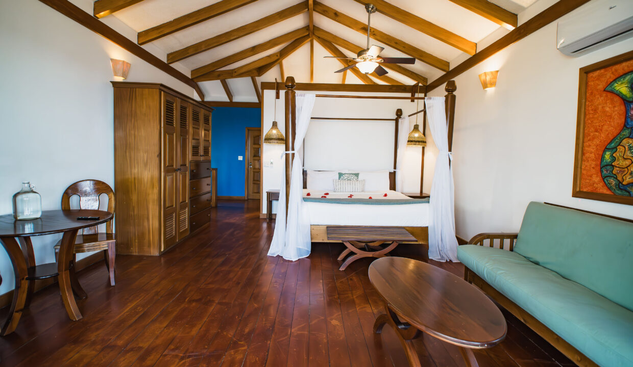 Spacious Master Suite With Lounge Area At Hopkins Bay Resort Belize Luxury Caribbean Villa Interior With Wooden Floors And High Ceilings