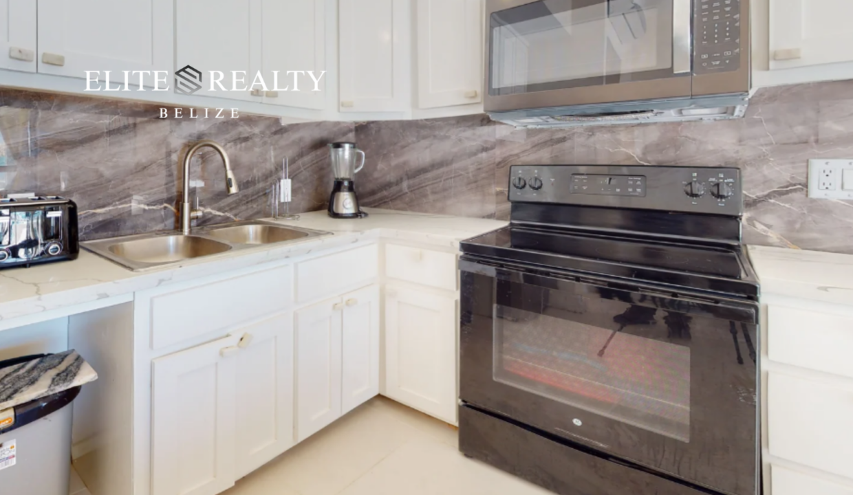 Kitchen With Stove Microwave Sink And Cabinetry In Beachfront Condo At Blue Water Beach Resort Ambergris Caye Belize