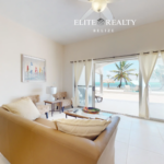 Living room with ocean view and sliding doors to beachfront patio at Blue Water Beach Resort Ambergris Caye Belize