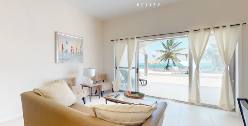 Living room with ocean view and sliding doors to beachfront patio at Blue Water Beach Resort Ambergris Caye Belize