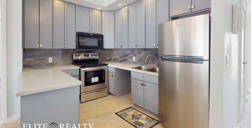 Modern kitchen with stainless steel appliances and quartz countertops in beachfront condo at Blue Water Beach Resort San Pedro Ambergris Caye Belize