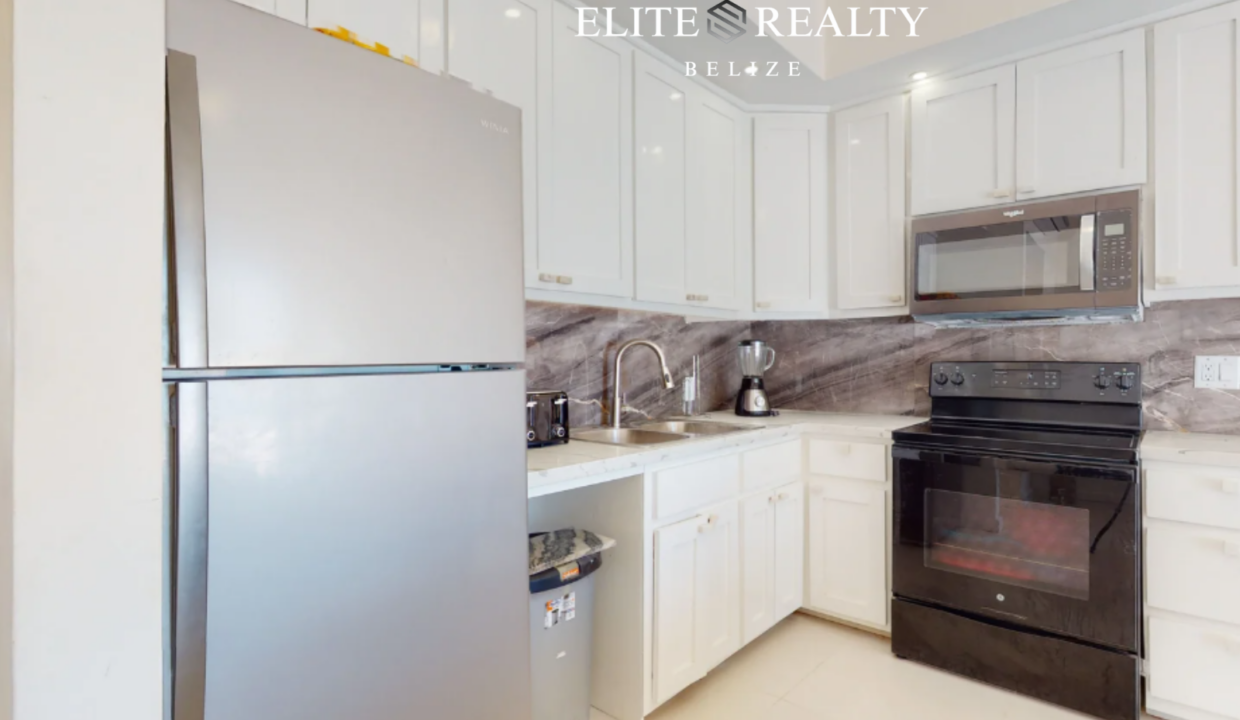 Modern Kitchen With Stainless Steel Refrigerator Stove Microwave And Cabinetry In Beachfront Condo At Blue Water Beach Resort Ambergris Caye Belize