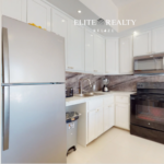Modern kitchen with stainless steel refrigerator, stove, microwave, and cabinetry in beachfront condo at Blue Water Beach Resort Ambergris Caye Belize