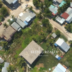 Aerial view of residential neighborhood with road access and nearby homes in Ambergris Caye Belize