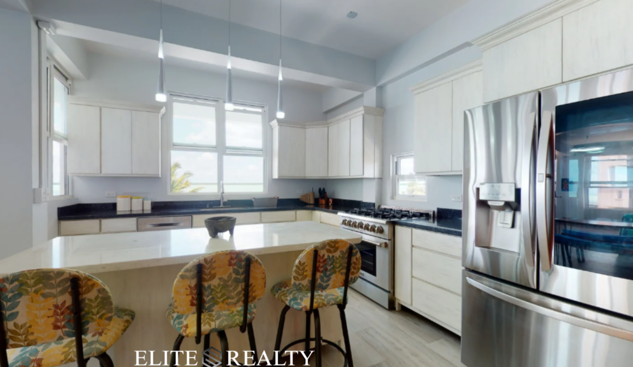 Modern Kitchen With Island Seating And Stainless Steel Refrigerator In Ambergris Caye Belize