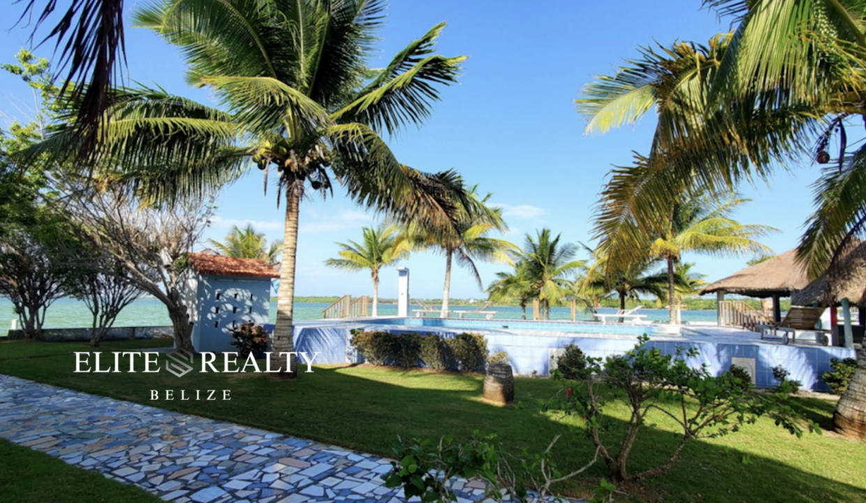 Palm Trees And Landscaped Grounds Surrounding The Waterfront Pool At Tarpon Cove Estates In Corozal Belize